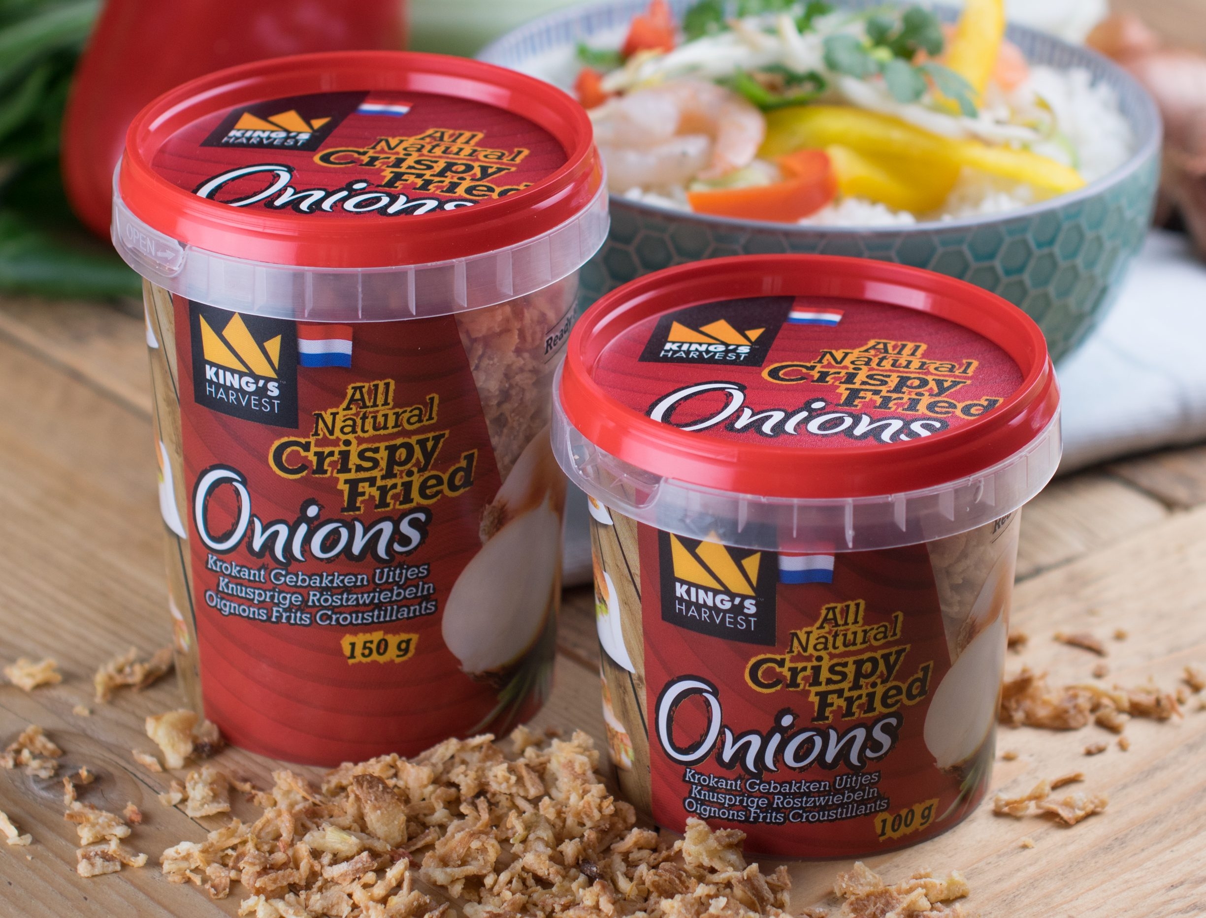 Verpakkingen gebakken uitjes in potjes op tafel met gerecht op de achtergrond Lion Foods